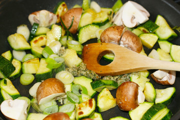 Gesunde Ernährung - Gemüsepfanne, Gemüse in der Pfanne beim Anbraten, Pilze, Zucchini, Lauch, Pesto und Rosmarin, vegane und vegetarische Lebensweise