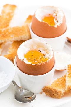 soft boiled eggs and crispy toast for breakfast, vertical