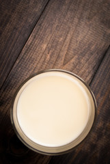 Glass of milk on wooden background