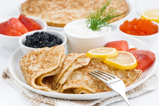 traditional Russian crepes with caviar and salted fish, closeup