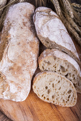 ciabatta with ears of wheat on a white wooden table