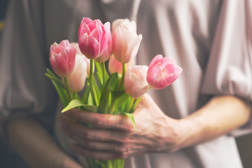 Bouquet of pink tulips in female hands