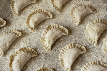 Homemade dumplings, uncooked, only molded on a linen tablecloth.
