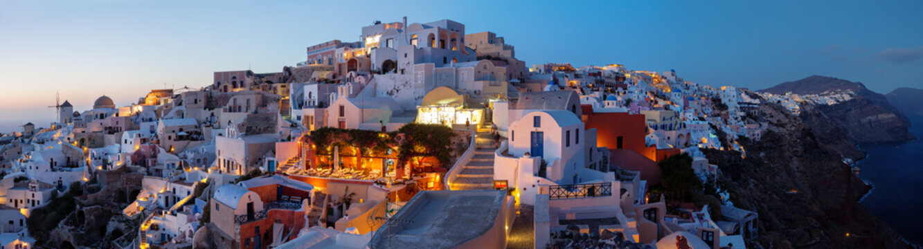 Sunset over traditional whitewashed houses in the cliffside town of Oia, Santorini, Greece