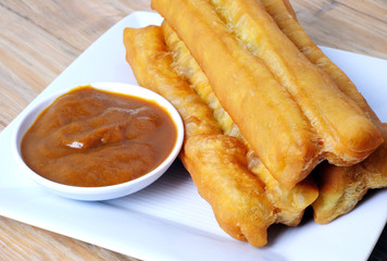 Horizontal photo of fried bread stick with coconut jam, the bread is also popularly known as Youtiao and Cakoi, a popular Chinese cuisine. The bread is also popular is Southeast Asian countries.