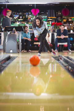 woman plays bowling and throws a ball