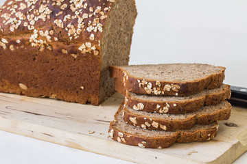 Brotscheiben und Brotlaib auf Holzbrett, Dinkelbrot, nah