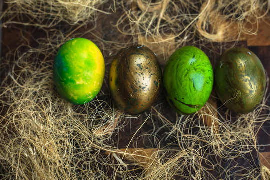 Green painted Easter eggs in a row