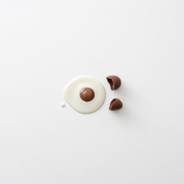 Conceptual cracked egg made of white and brown chocolate