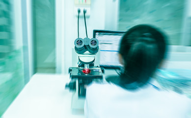 women with blue blur background and red ray use microscope for f