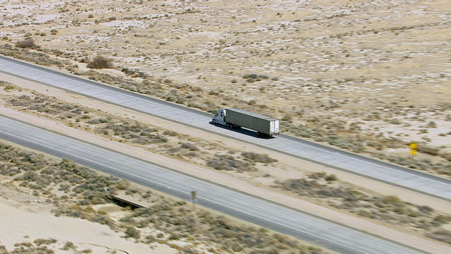 Freight truck driving on highway through desert