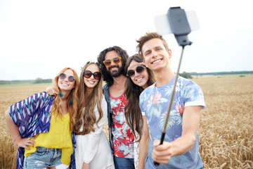 hippie friends with smartphone on selfie stick