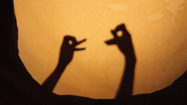 A silhouette shadow show of two birds and two deer playing with each other