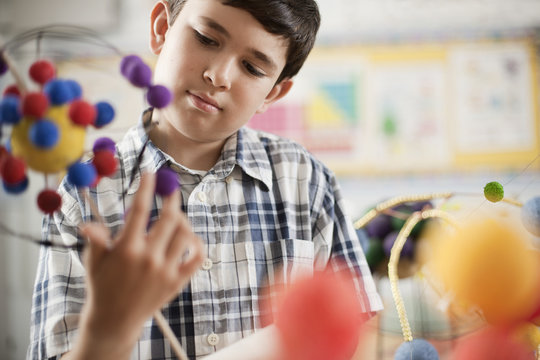 A boy examining a molecular structure in a science lesson, 