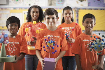 A group of girls and boys wearing the teeshirt of the Science Club, making molecular structure models, 