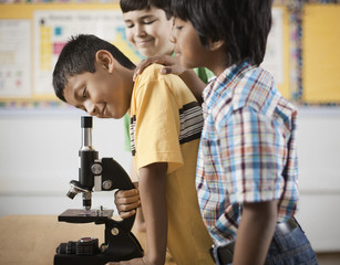 Two children using a microscope,