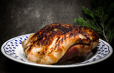 roasted pork ham in a dish on dark flat stone ambient 