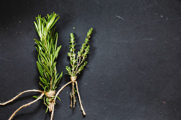 Rosemary and thyme bounds on a dark grey board
