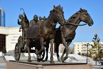 Naklejka na ściany i meble Statue featuring historic Kazakh warriors on a chariot in front of the Historical Museum in Astana, Kazakhstan