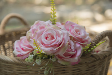 Many fake pink roses in a basket