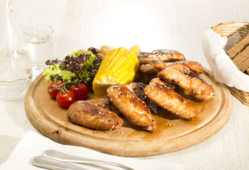 chicken wings are grilled on a wooden platter