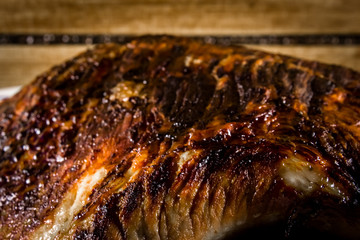 Obraz na płótnie Canvas roasted pork ham in a dish on dark wooden ambient 