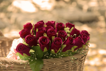 Many fake flowers, red roses in a basket