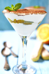 Italian dessert tiramisu with orange in a glass.