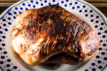 roasted pork ham in a dish on dark wooden ambient 