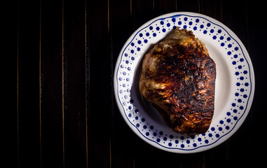 roasted pork ham in a dish on dark wooden ambient 