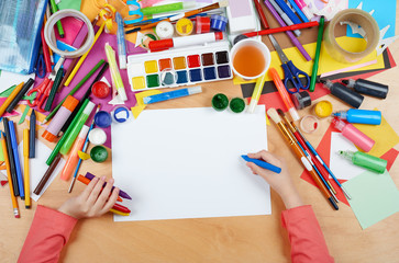 Child drawing top view. Artwork workplace with creative accessories. Flat lay art tools for...