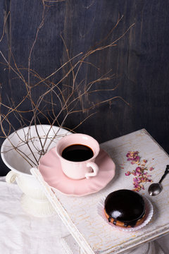 Dessert, chocolate cupcake with coffee and rose petals on atique wooden table.