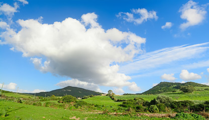 Fototapeta na wymiar green hills under a blue sky with clouds