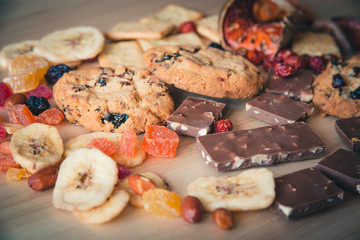 Cookies with chocolate are handmade. On the background of dried fruits and chocolate on wooden background