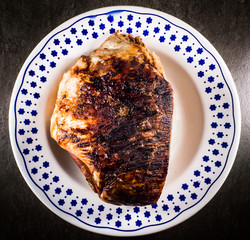 roasted pork ham in a dish on dark flat stone ambient 