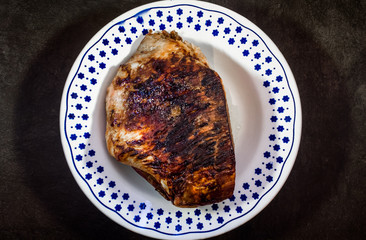 roasted pork ham in a dish on dark flat stone ambient 