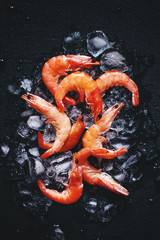 Food background, frozen cooked shrimp with ice, black background