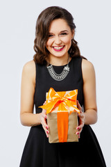 Pretty young woman posing on white background with present