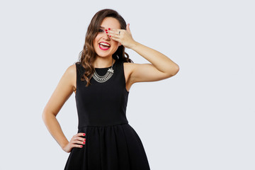 Cheerful brunette woman close her eye by her hand