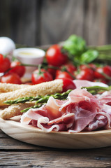 Antipasto with ham and green asparagus