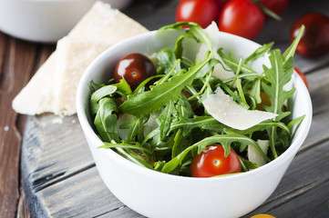Healthy salad with rocket, tomato and parmesan cheese