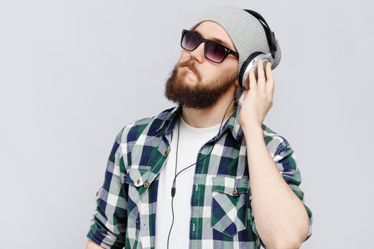 Young concentrated man listening to music on headphones