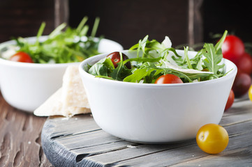 Healthy salad with rocket, tomato and parmesan cheese