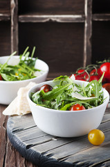 Healthy salad with rocket, tomato and parmesan cheese