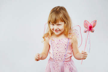Beautiful little girl posing with magic stick in studio