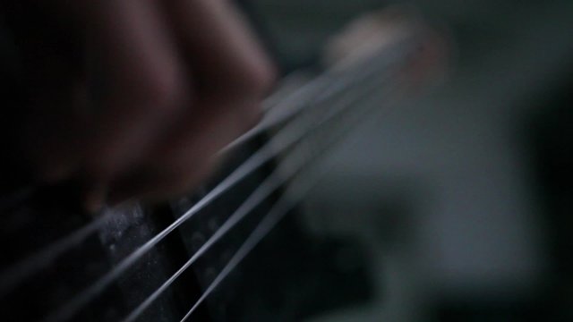 bass guitarist fingering the strings