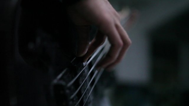 bass guitarist fingering the strings
