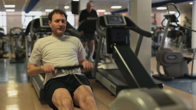 Man in the gym working on the rowing machine