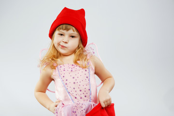 Dissatisfied little girl posing with red bag in studio