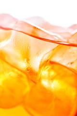 detail or macro photography of aperol spritz in wine glass with ice cubes